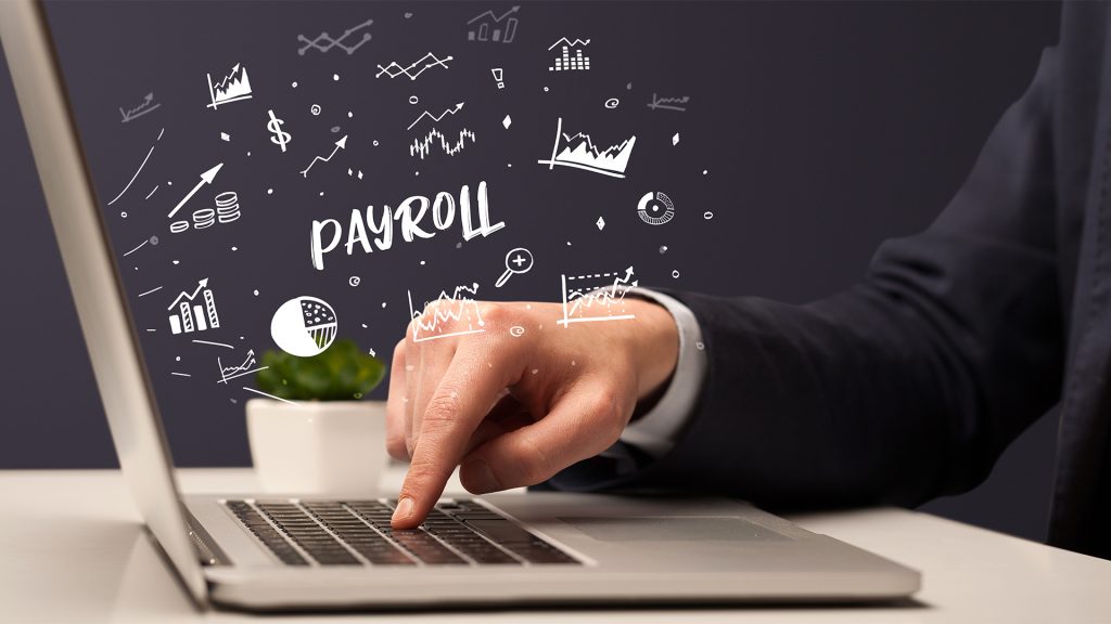 Businessman working on laptop with PAYROLL inscription